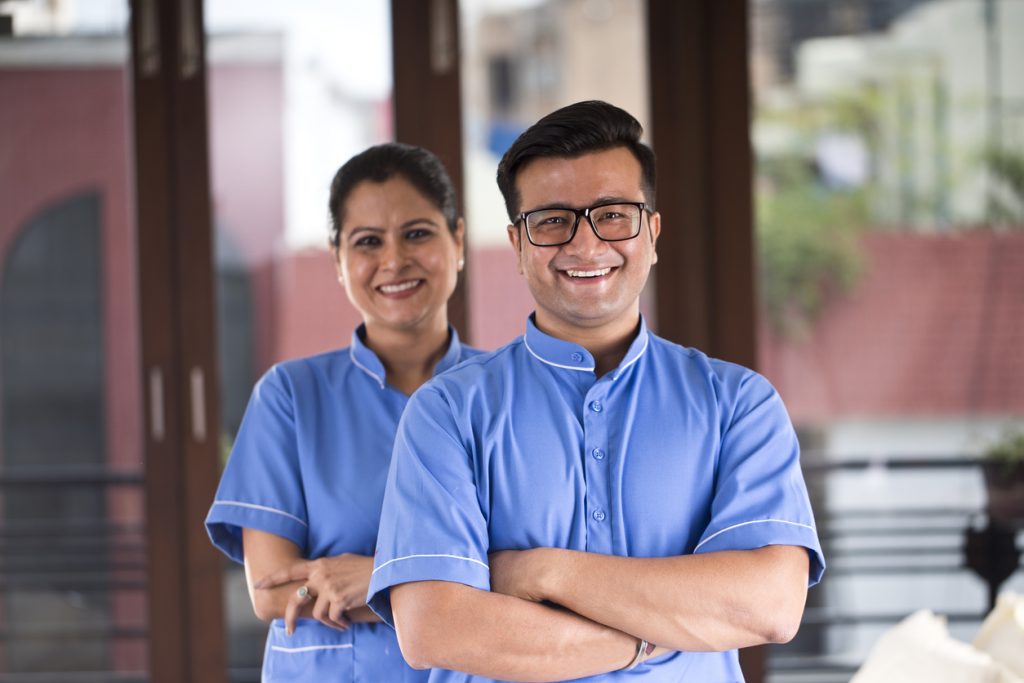 Confident male and female nurse at hospital feeling proud in caring aged people.